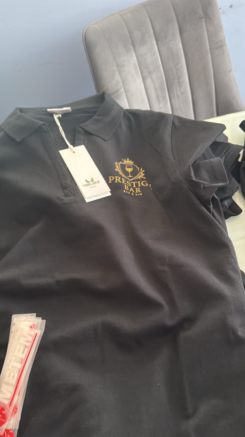 Polo noir avec logo Prestige Bar à Vin imprimé en DTF doré